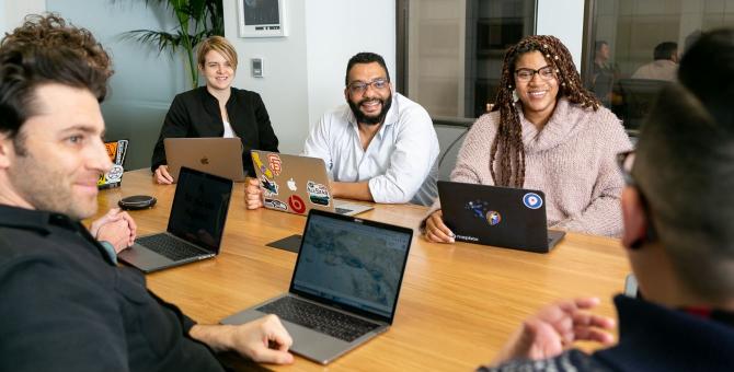 people meeting in an office with computers