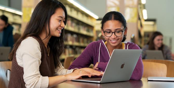 Teens in library with a Mac computer